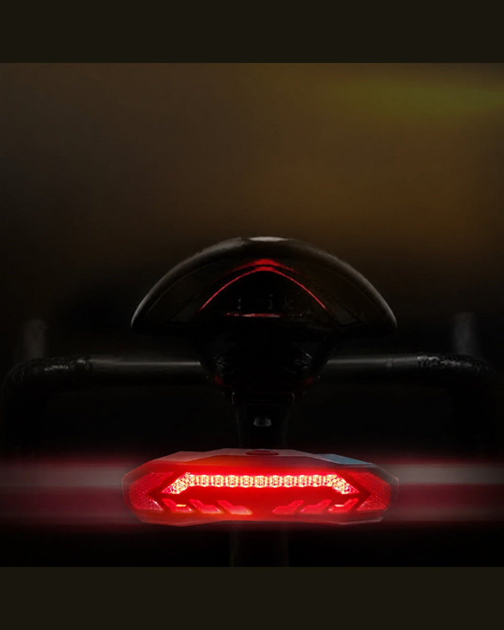 Rear close-up of an OPlace bike tail light glowing red at night