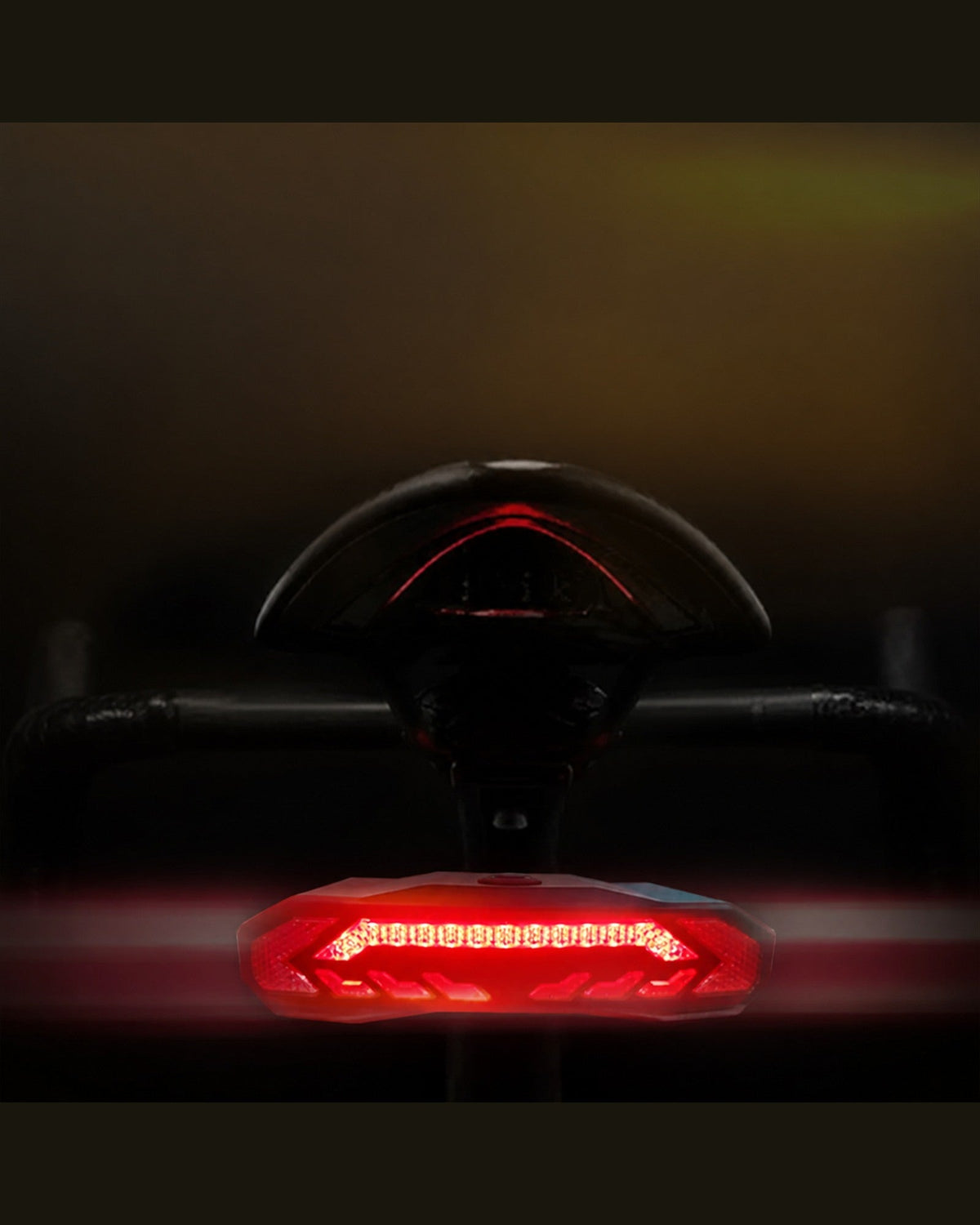Rear close-up of an OPlace bike tail light glowing red at night