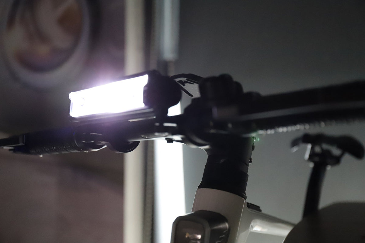 Multi-LED USB-C rechargeable bike front light mounted on a handlebar with a bright white beam