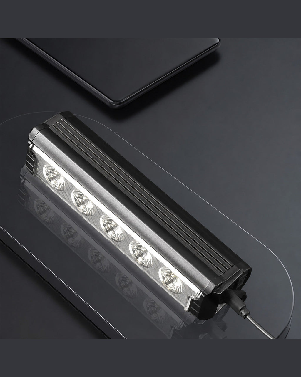 Multi-LED USB-C rechargeable bike front light shown close-up with a cable on a dark surface