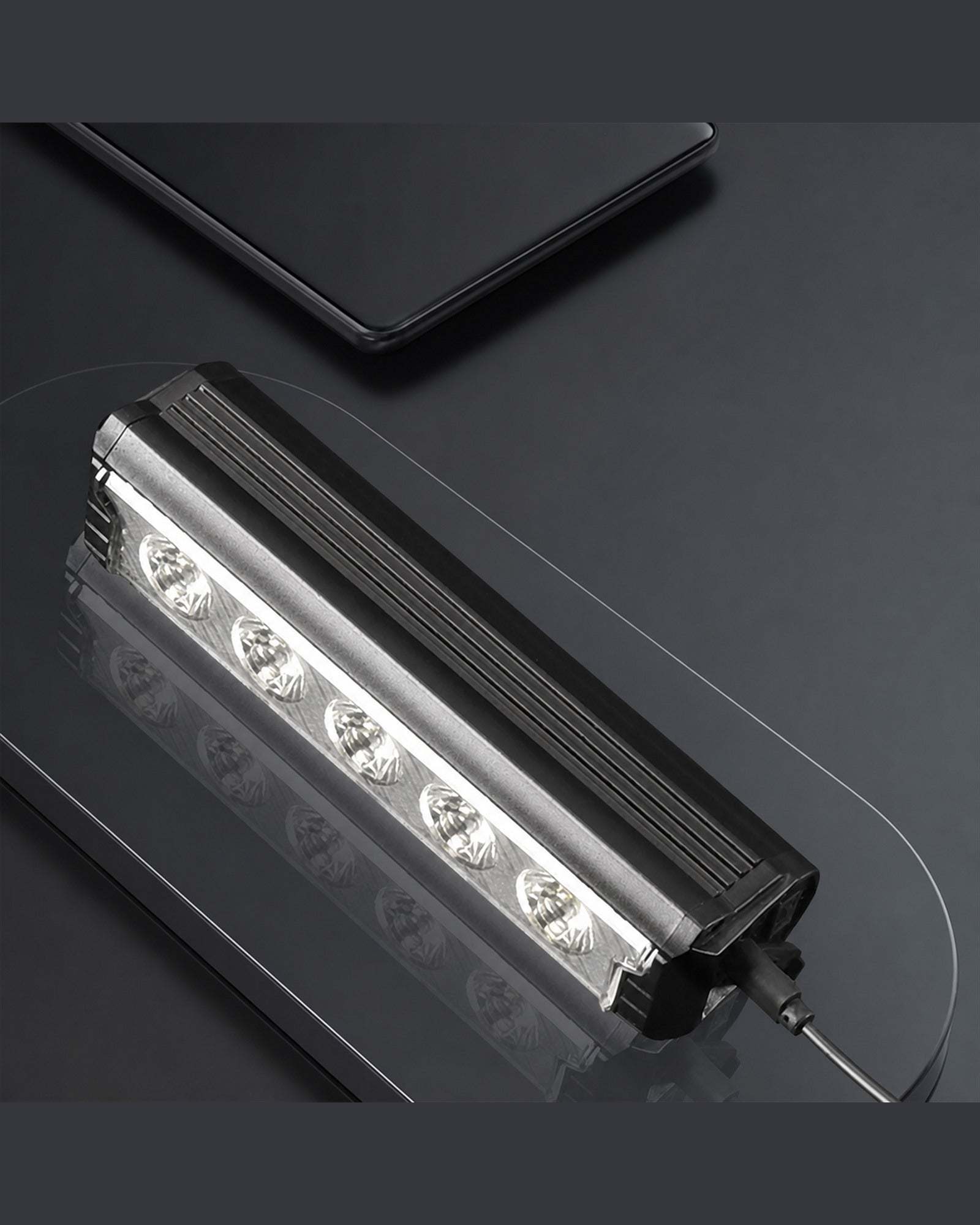 Multi-LED USB-C rechargeable bike front light shown close-up with a cable on a dark surface