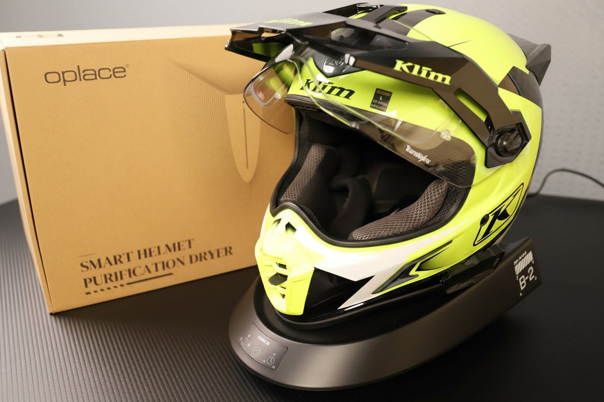 Smart Helmet and Gear Dryer Pro supporting a neon yellow motocross helmet beside its box