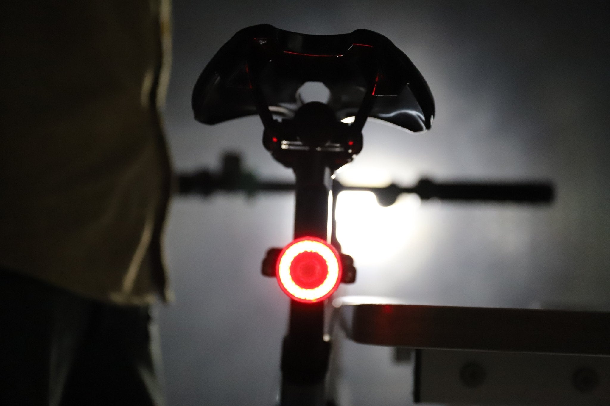 Rear bicycle view with a vivid red circular halo light beneath the saddle
