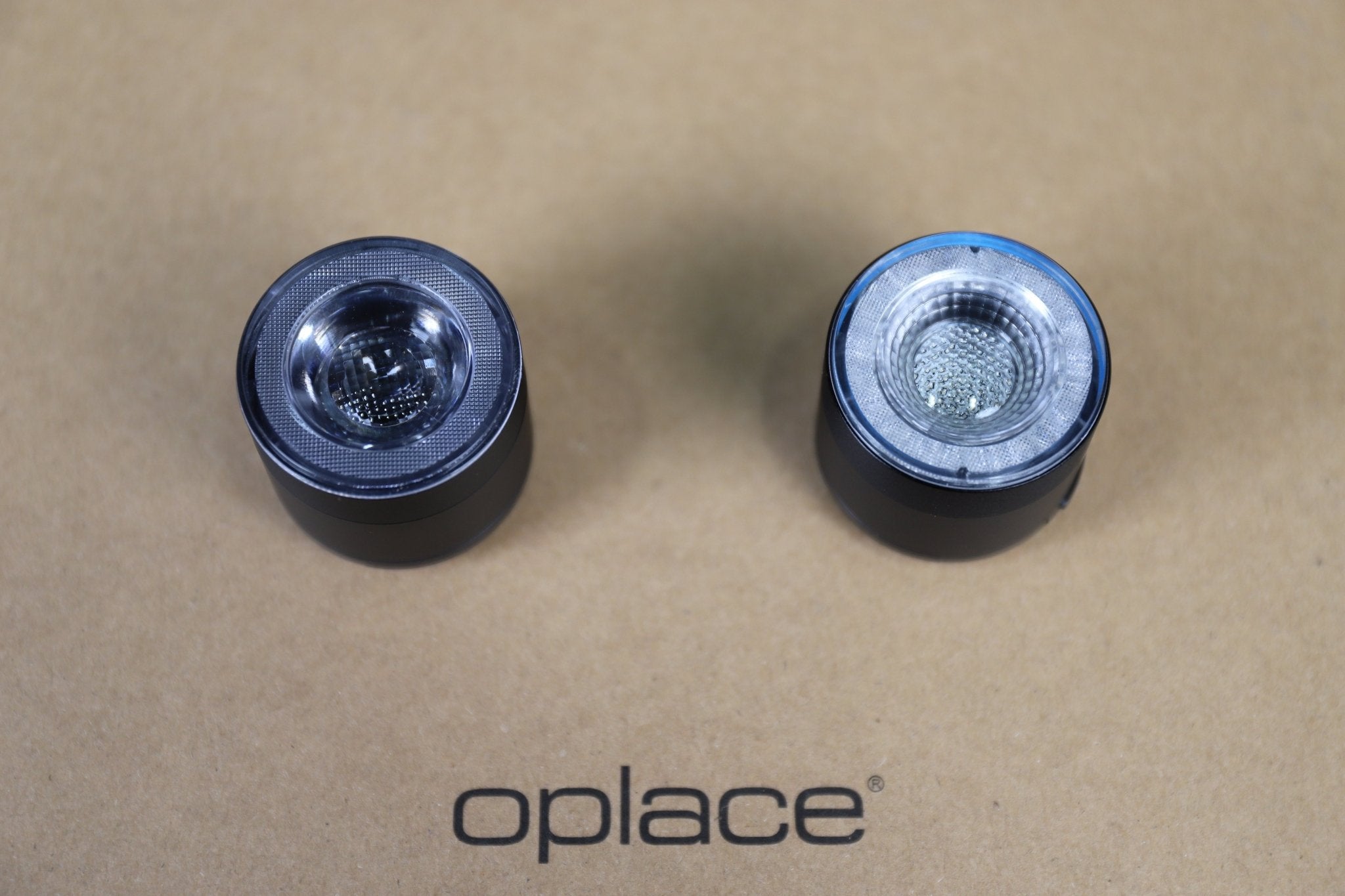 Pair of round RGB halo bike lights displayed on a kraft-colored OPlace background