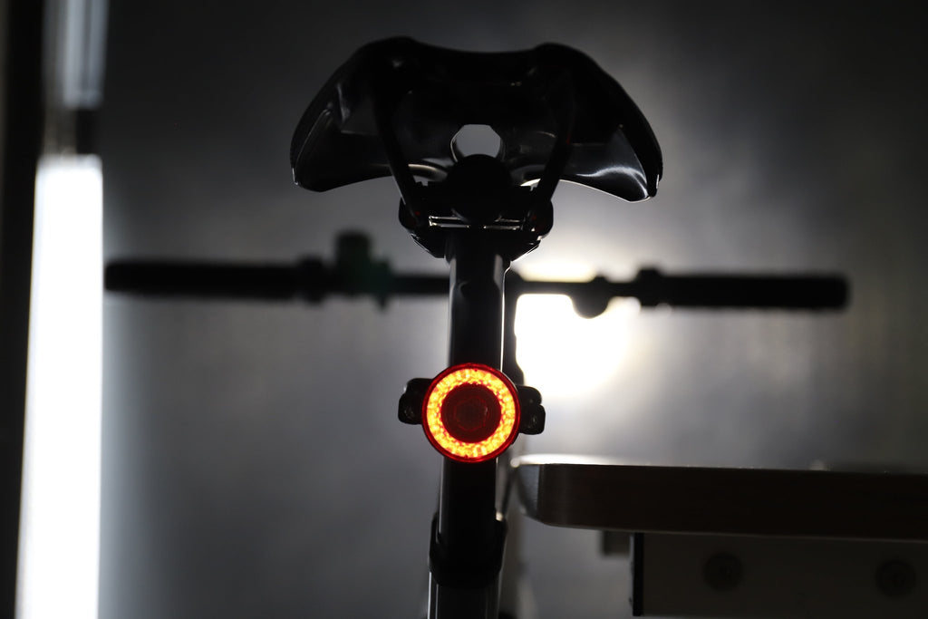 Rear bicycle view with an amber halo light glowing beneath the saddle