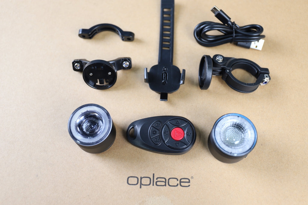 RGB halo bike light set with two round lights, wireless remote, mounts and cables arranged together