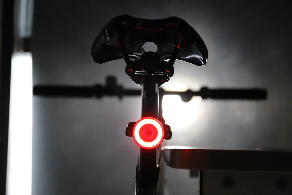 Rear bicycle view with a red halo light glowing beneath the saddle