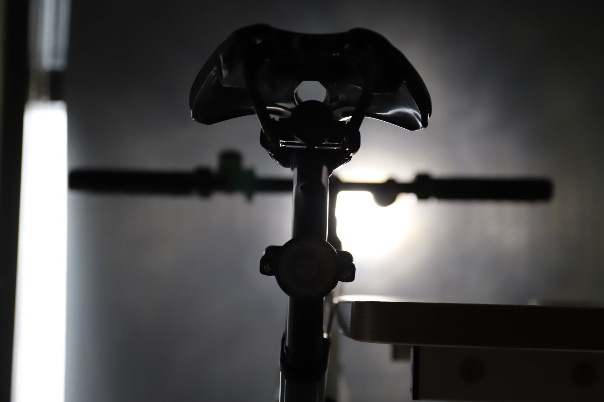 Rear bicycle view with a circular halo light glowing beneath the saddle