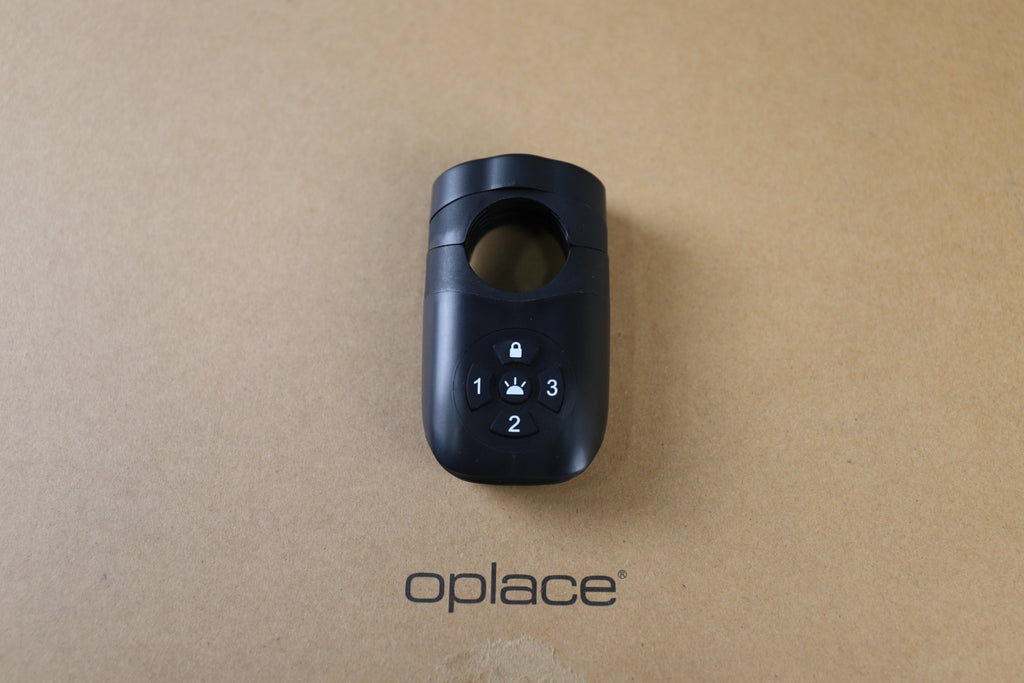 Find My-ready alarm bike tail light displayed on an OPlace box with its control buttons visible