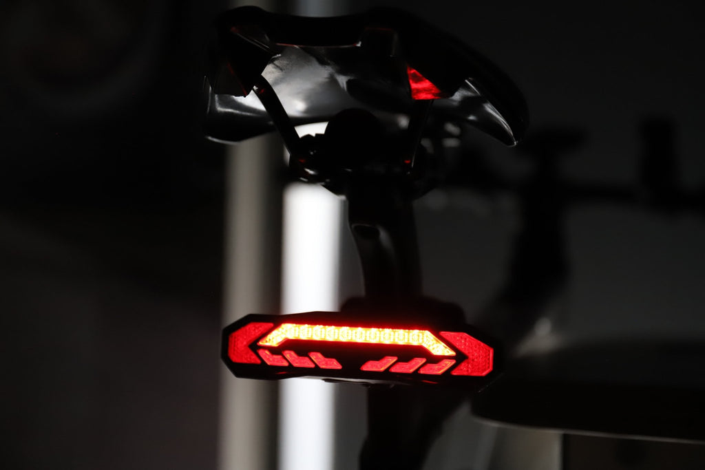Red OPlace bike tail light mounted under a saddle indoors