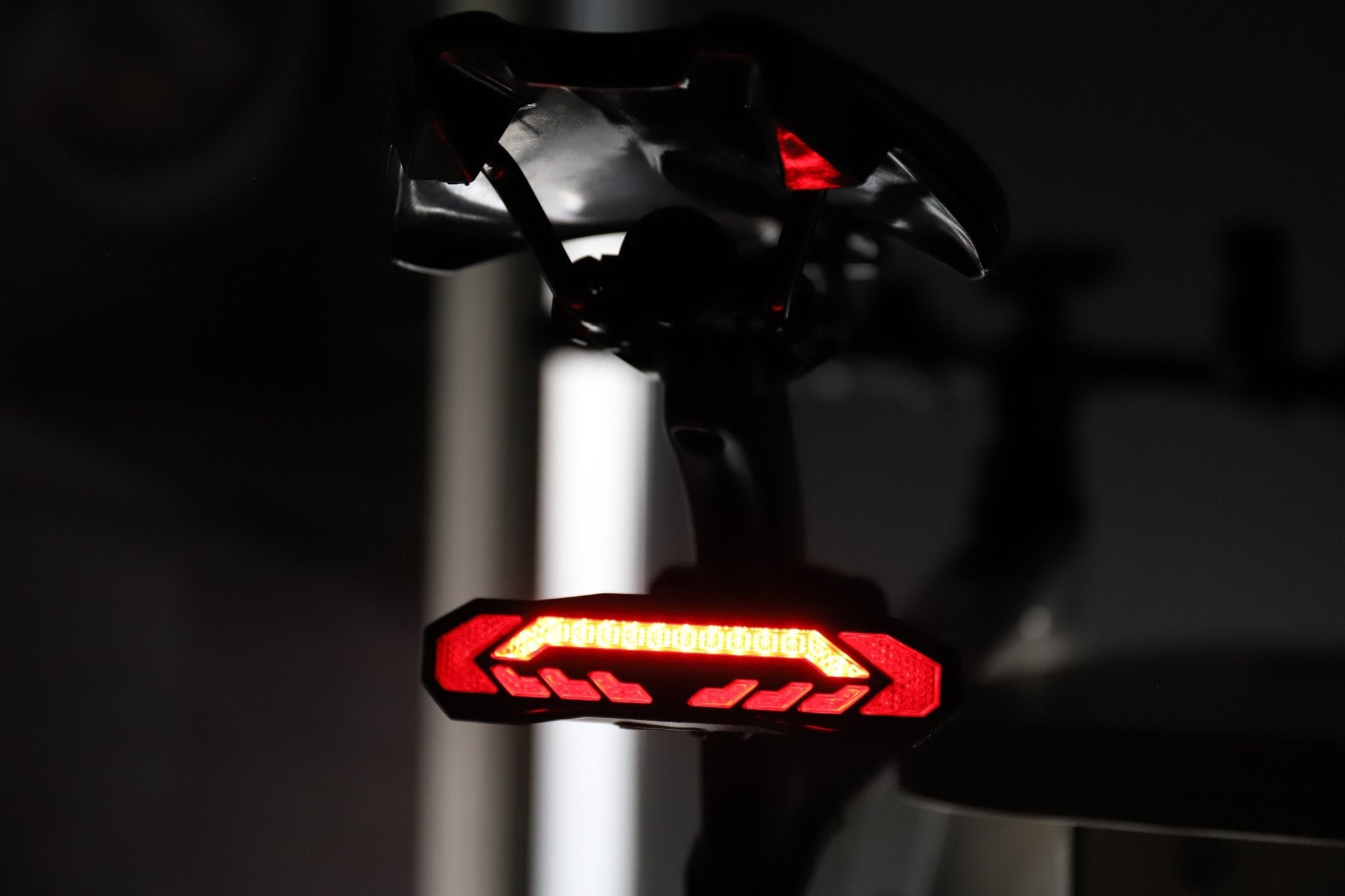 Red OPlace bike tail light mounted under a saddle indoors