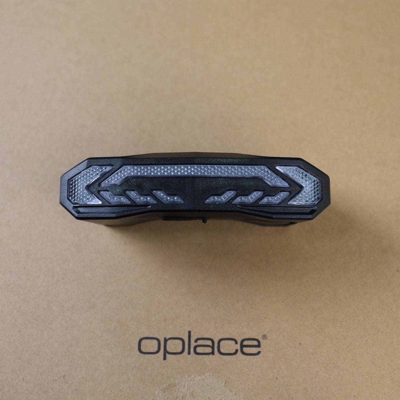 OPlace alarm bike tail light resting on branded cardboard